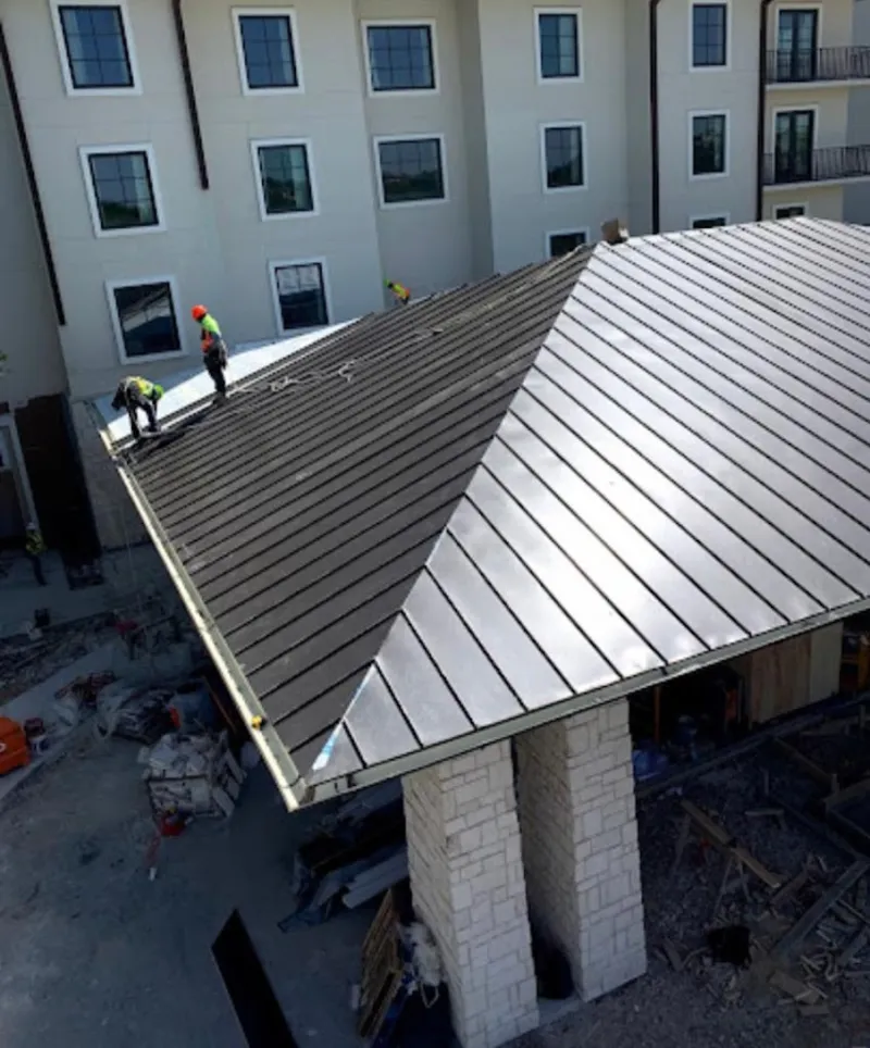 Crew installing standing seam metal roof panels on a commercial project in Alderwood Manor